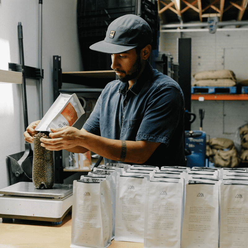 Middle State Coffee roaster filling bags with specialty coffee